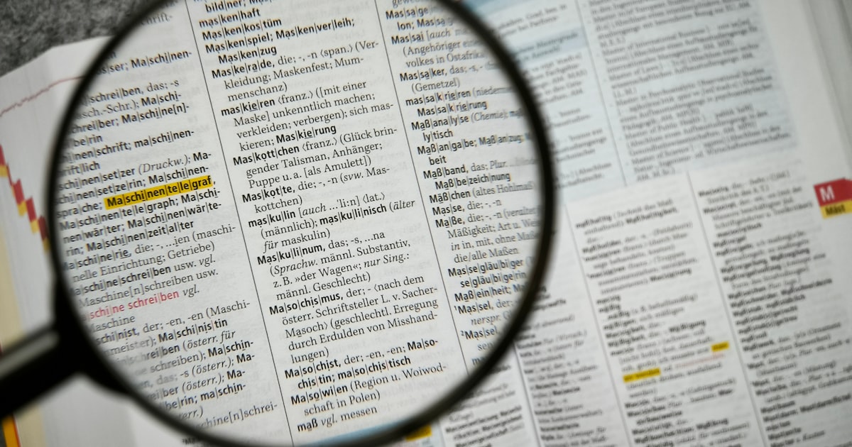 돋보기로 문서의 텍스트를 확대하여 들여다보는 모습